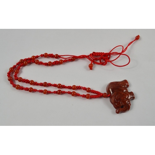 68 - Vintage Brown Jade style carved Elephant suspended from a 48cm cord and reddish bead necklace.