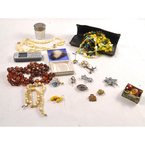 66 - Selection of costume jewellery to include necklaces, amber 'style' beads brooches and a mobile phone... 