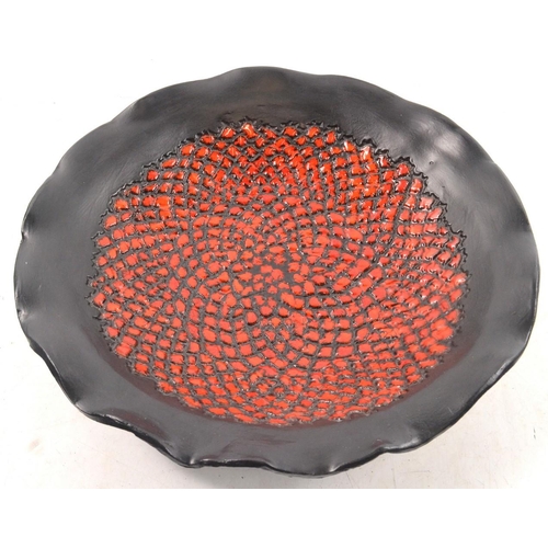 94 - A LARGE  POTTERY STUDIO ART PLATE finished in fiery red/ orange on black background 38cm diameter