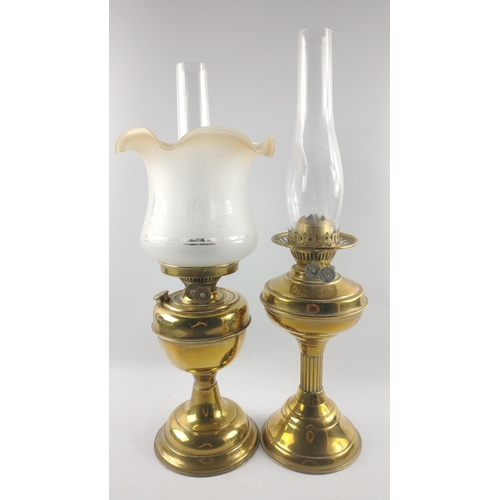 230 - Two brass-effect oil lamps, one with shade both with chimneys approx. 50cm each.#288
