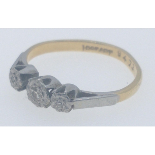 14 - An 18ct stamped yellow gold engagement ring, set in platinum with three diamonds inset, the middle d... 