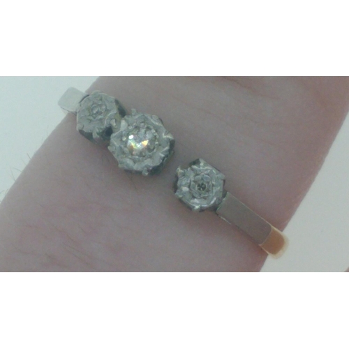 14 - An 18ct stamped yellow gold engagement ring, set in platinum with three diamonds inset, the middle d... 