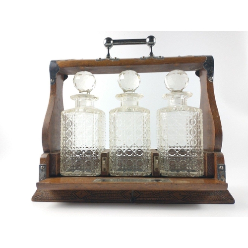 86 - A LATE VICTORIAN TANTALUS with cut glass decanters with stoppers in place and EPNS stamped metal wor... 