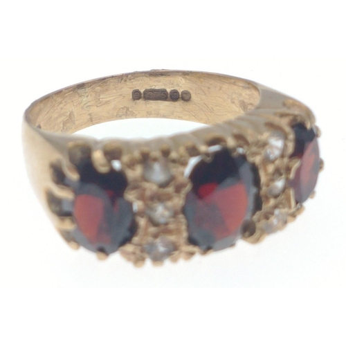 20 - A SUBSTANTIAL 375 stamped yellow gold ring set with a trio of garnets setting ring size N, weight gr... 