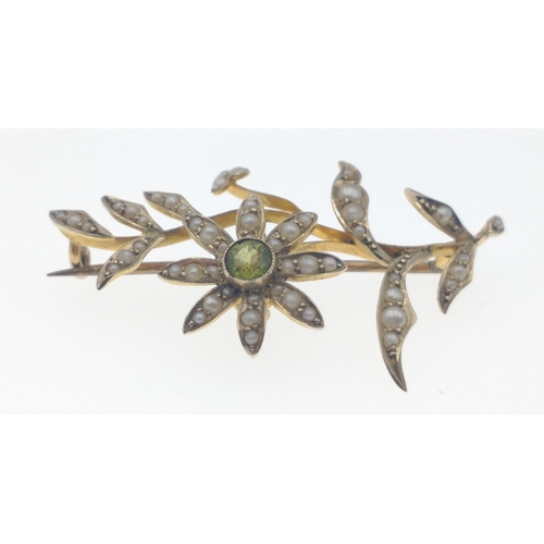 30C - A BEAUTIFUL 9ct  stamped flower form brooch with a central green stone and seed pearls adorning the ... 