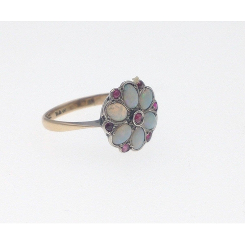 12B - A 9ct gold opal ring with 6 opals and 7 red stones in a flower-head pattern, size M/N gross weight 2... 