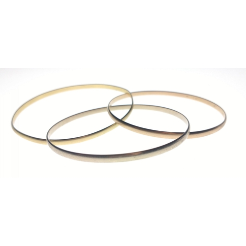 23 - CARTIER - A gold BANGLE, Cartier, three tri-tone gold interlocking bangles. 750 stamped rose, yellow... 