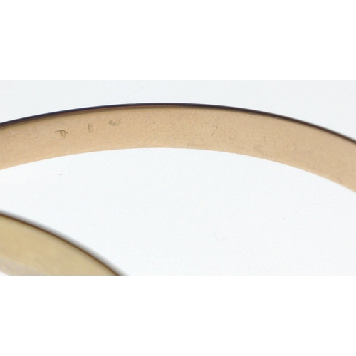 29 - CARTIER - A SUBSTANTIAL gold BANGLE, Cartier.Three tri-tone gold interlocking bangles. 750 stamped r... 