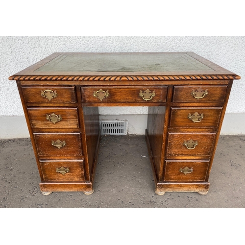 372 - Vintage c1900 kneehole oak desk with green leather top, on bun feet, middle drawer, four graduating ... 