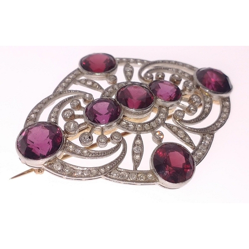 51 - ORNATE STUNNING ART DECO DESIGN! An unmarked diamond and garnet set BROOCH, with 7 round faceted gar... 