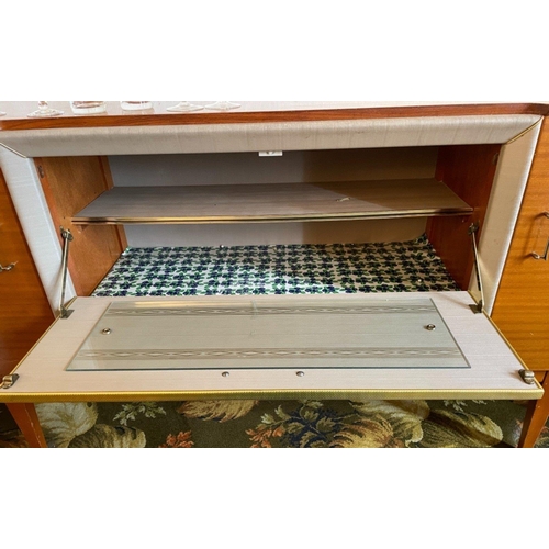 107 - A RETRO circa 1960's sideboard in teak with FEATURE fabric panel which pulls-down' to reveal a glas... 