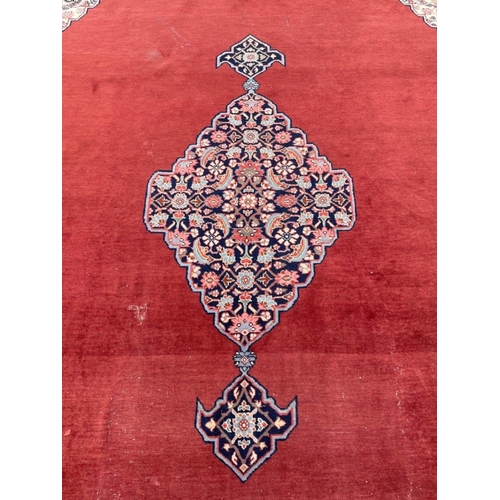 215 - An IMMENSE VINTAGE hand made CARPET FROM PAKISTAN with a terracotta background and traditional borde... 