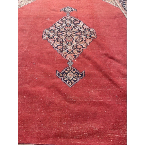 215 - An IMMENSE VINTAGE hand made CARPET FROM PAKISTAN with a terracotta background and traditional borde... 