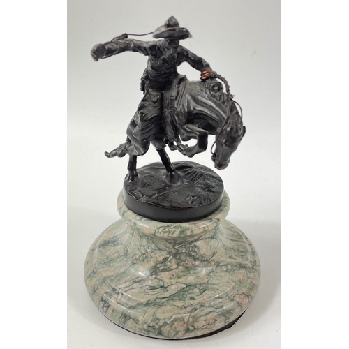 247 - Two small figurines of mounted cowboys on a marble plinth, in the style of Frederic Remington, no si... 