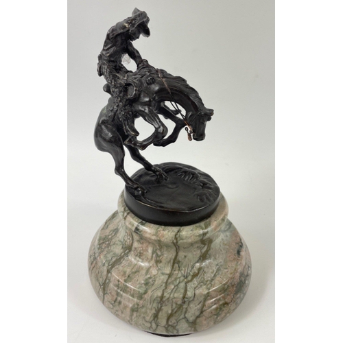 247 - Two small figurines of mounted cowboys on a marble plinth, in the style of Frederic Remington, no si... 