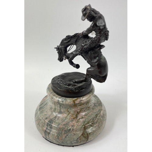 247 - Two small figurines of mounted cowboys on a marble plinth, in the style of Frederic Remington, no si... 