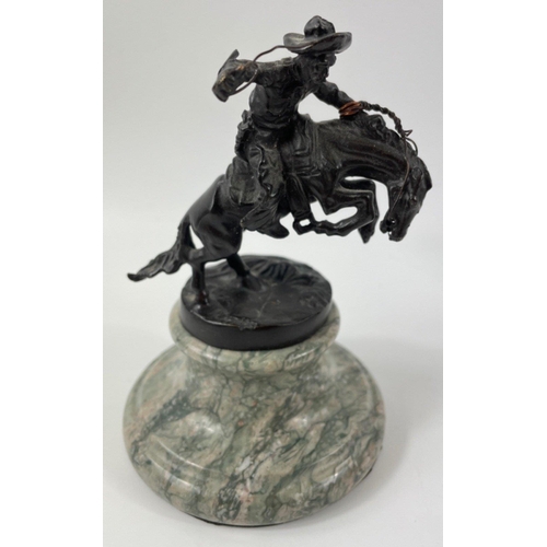 247 - Two small figurines of mounted cowboys on a marble plinth, in the style of Frederic Remington, no si... 