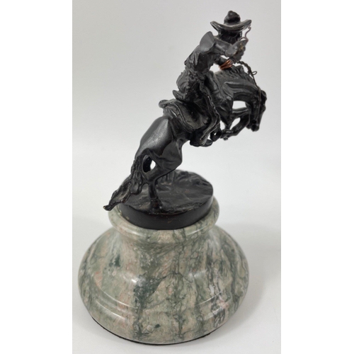 247 - Two small figurines of mounted cowboys on a marble plinth, in the style of Frederic Remington, no si... 