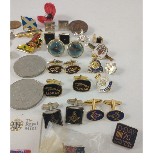 28 - A box of mixed tie pins, lapel badges plus two each of commemorative crown coins to include Churchil... 
