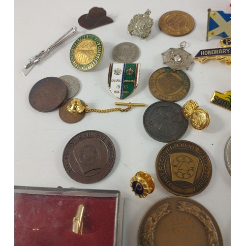 28 - A box of mixed tie pins, lapel badges plus two each of commemorative crown coins to include Churchil... 