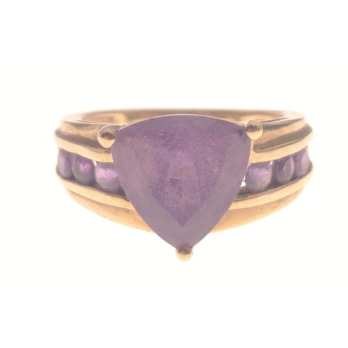 1 - A STUNNING AND SUBSTANTIAL 9K stamped yellow gold ring with a large triangular-cut AMETHYST stone ce... 