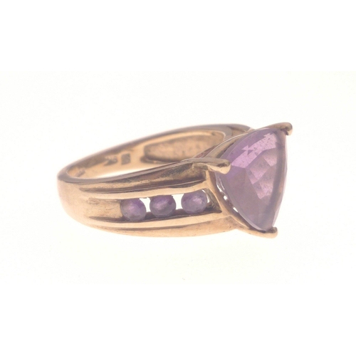 1 - A STUNNING AND SUBSTANTIAL 9K stamped yellow gold ring with a large triangular-cut AMETHYST stone ce... 