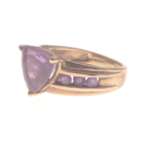 1 - A STUNNING AND SUBSTANTIAL 9K stamped yellow gold ring with a large triangular-cut AMETHYST stone ce... 