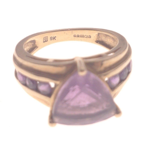 1 - A STUNNING AND SUBSTANTIAL 9K stamped yellow gold ring with a large triangular-cut AMETHYST stone ce... 