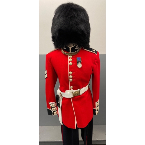 120 - A SCOTS GUARDS CEREMONIAL UNIFORM comprising a bearskin and brass-decorated chinstrap, a red tunic (... 