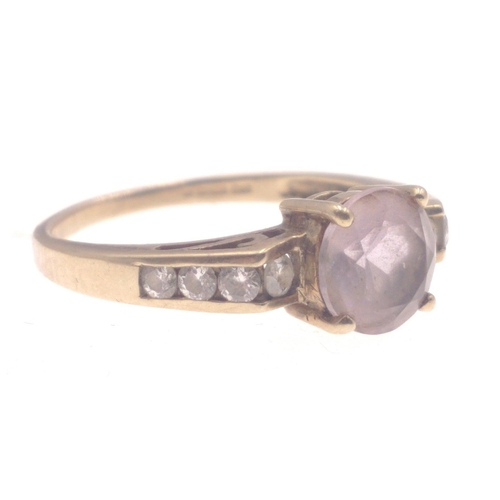 1 - A 9k stamped yellow gold ring with central amethyst flanked by three diamonds(tested) on each should... 