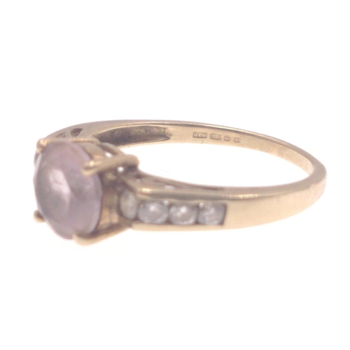 1 - A 9k stamped yellow gold ring with central amethyst flanked by three diamonds(tested) on each should... 