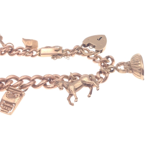 33 - A gold 375 charm bracelet with 7 charms, six of which are stamped 375, bracelet length approx 18cm, ... 