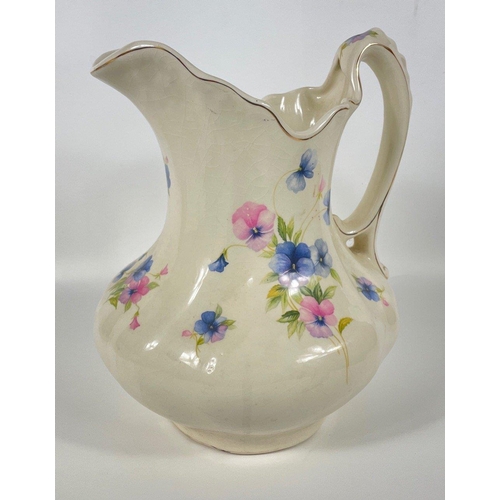 128 - A large vintage ewer and basin with a design of pansies, ewer stands 28cm high, basin with scalloped... 