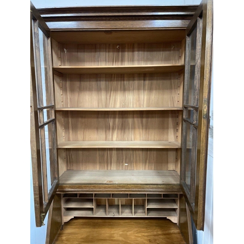 277A - A circa 1930's oak antique library and fitted bureau cabinet, with two glazed doors and four shelves... 