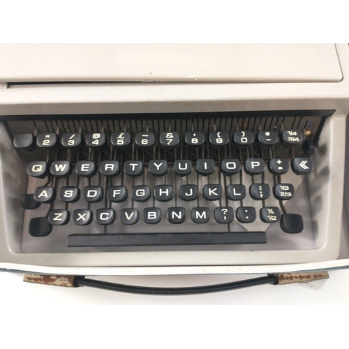 406 - An OLIVETTI DORA portable typewriter in original blue carrying case with instructions#470