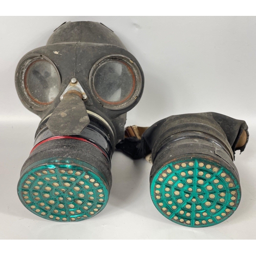 107A - Two GAS MASKS, the first, in a fragile state, is a rare civilian single eyepiece respirator stamped ... 