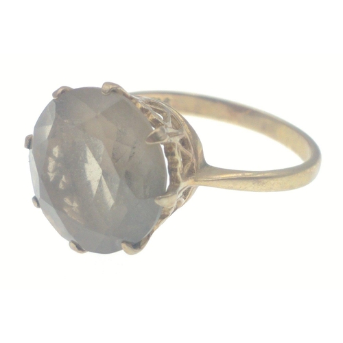 6 - A 9ct stamped yellow gold ring with a large cut Smokey quartz stone inset- supported with intricate ... 