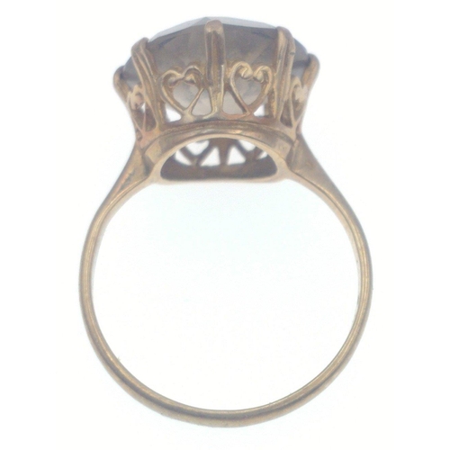 6 - A 9ct stamped yellow gold ring with a large cut Smokey quartz stone inset- supported with intricate ... 