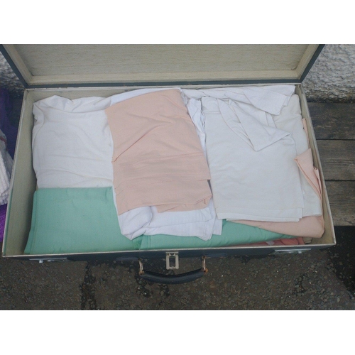 345 - A large Globetrotter suitcase (75x38x25cm approx), filled with bedding to include sheets, blankets a... 