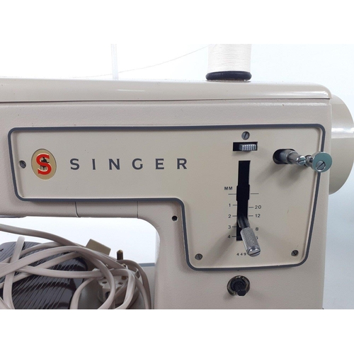 352 - An electric Singer sewing machine complete with carry case green cover. 41.7cm wide at top including... 