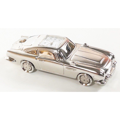 142 - ASTON MARTIN a miniature metallic silver model car (8cm long) with embedded quartz clock plus a set ... 