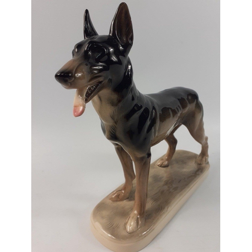 395 - A ceramic figure of a GERMAN SHEPHERD with an indistinct mark to the base the figure is 22cm tall#39... 