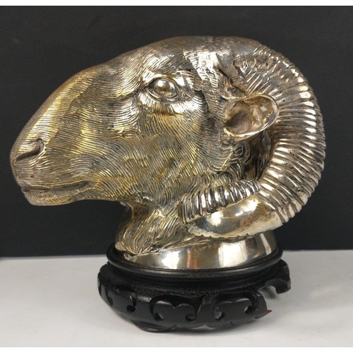 180 - A silvered bronze ram's head with wooden plinth, can be wall-mounted, stands approx 15cm tall, 20cm ... 