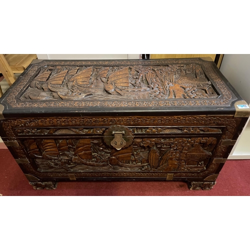 217 - An ORIENTAL lidded chest with nice carving detail and brass detailed corner fixings - dimensions 98c... 