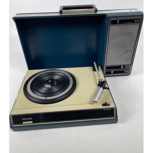 254 - A vintage PHILIPS briefcase-style portable record player with a dark blue cover, still has adapter f... 