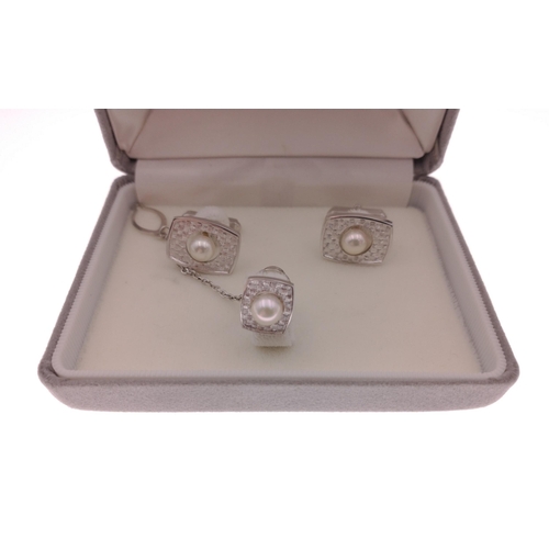 40A - A SILVER stamped pearl set cufflinks and tie stud set within its original jeweller's presentation bo... 