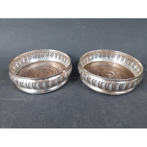 78 - An impressive pair of sterling silver wine stands / bottle coasters with wooden bases.  Full hallmar... 