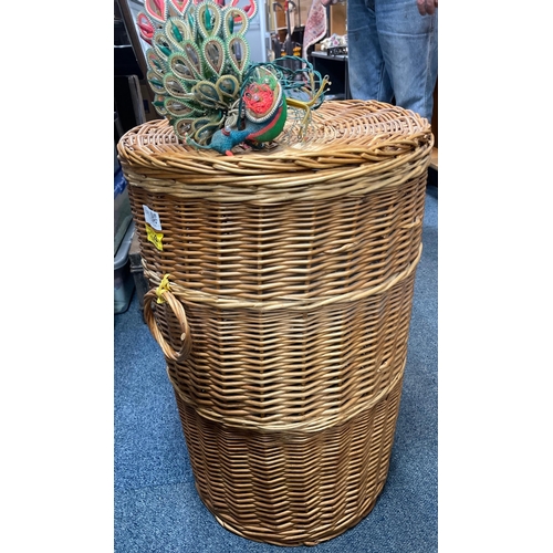 51 - A large wicker lidded laundry basket - dimensions height 60cm x 40cm diameter with a small window el... 