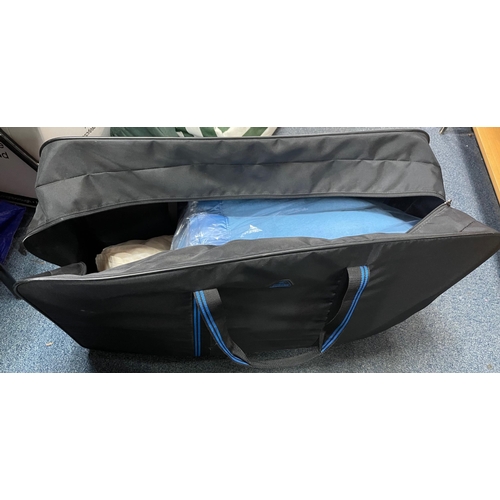 89 - A large soft black nylon zipper suitcase with contents to include large blankets some still in their... 