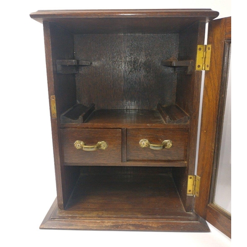 199 - An cEDWARDIAN Oak SMOKERS CABINET with a glazed door fitted with a working lock and key , ideal for ... 